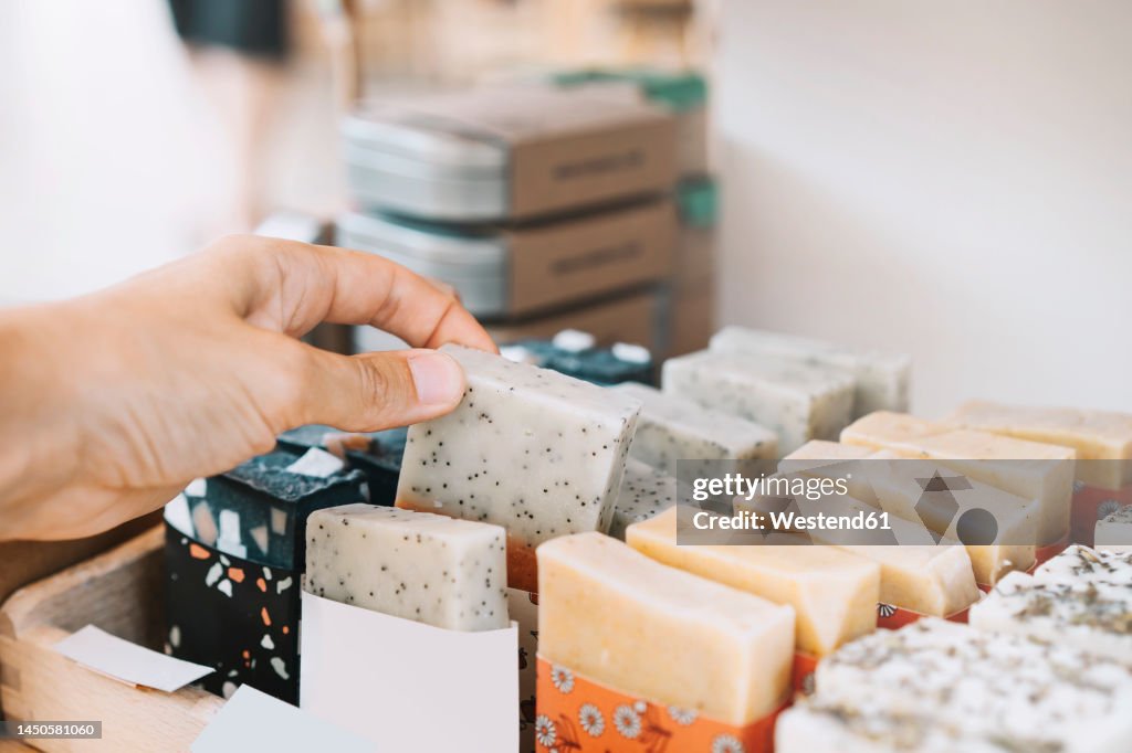 Woman picking scented soap bar at zero waste shop