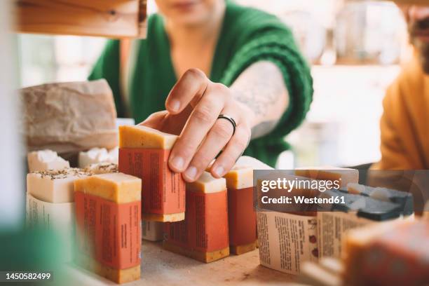 woman picking up soap bar from rack in shop - duurzaam consumeren stockfoto's en -beelden