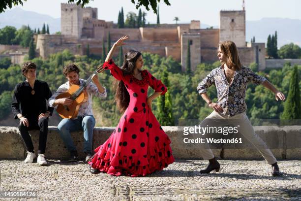 dancers and musician performing flamenco on sunny day in front of alhambra, granada, spain - flamencos stock pictures, royalty-free photos & images