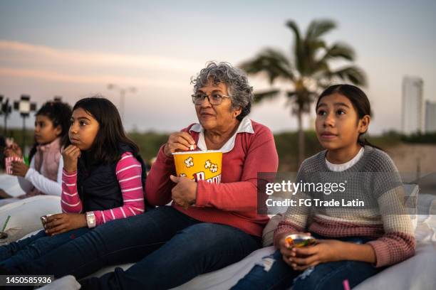 abuela con nietos viendo una película en el cine al aire libre - reality tv fotografías e imágenes de stock