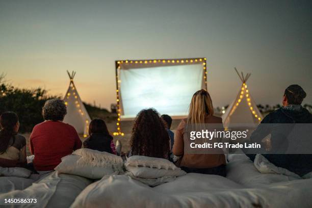 group of people watching a movie at the outdoors cinema - outdoor film screening stock pictures, royalty-free photos & images