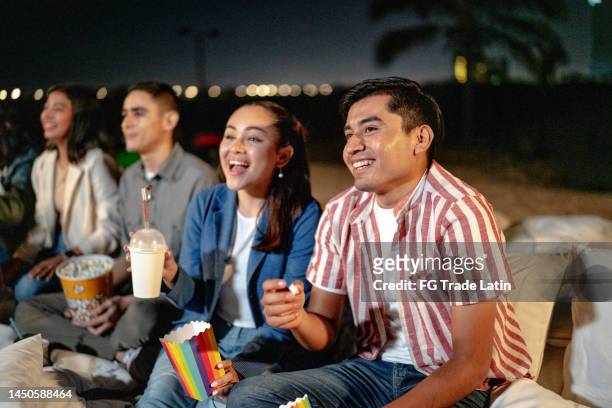 young couple watching a movie at the outdoors cinema - cinema club stock pictures, royalty-free photos & images