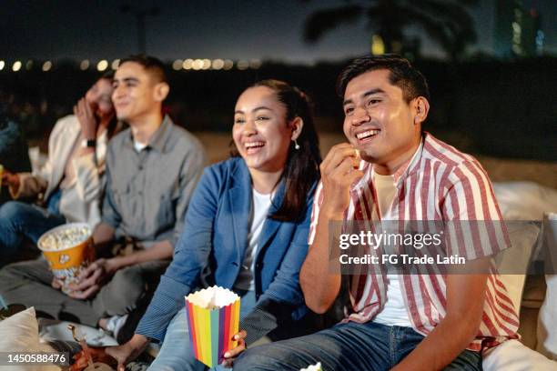 young couple watching a movie at the outdoors cinema - funny mexican cartoon stockfoto's en -beelden