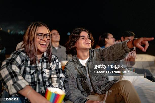 young couple watching a movie at the outdoors cinema - funny mexican cartoon stockfoto's en -beelden