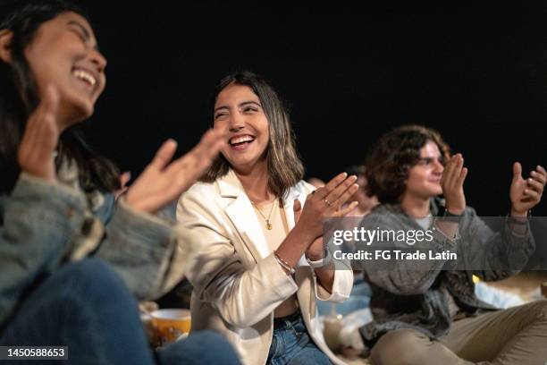 grupo de amigos viendo una película al aire libre - aplaudir fotografías e imágenes de stock