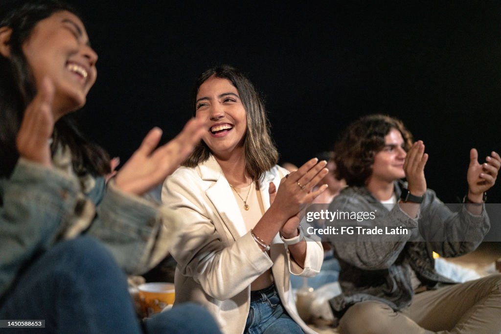 Group of friends watching a movie outdoors