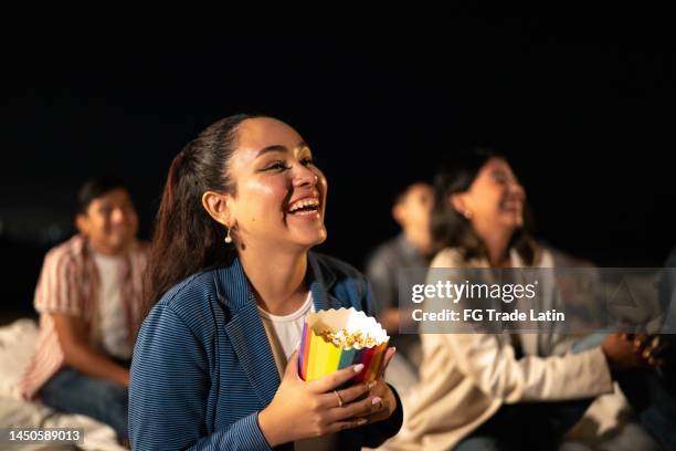 mujer joven viendo una película. en el cine al aire libre - festival de film fotografías e imágenes de stock