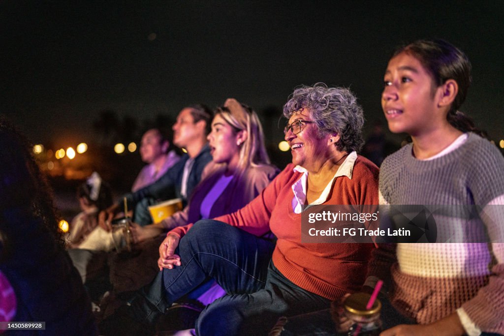 Group of people enjoying a movie at the outdoors cinema