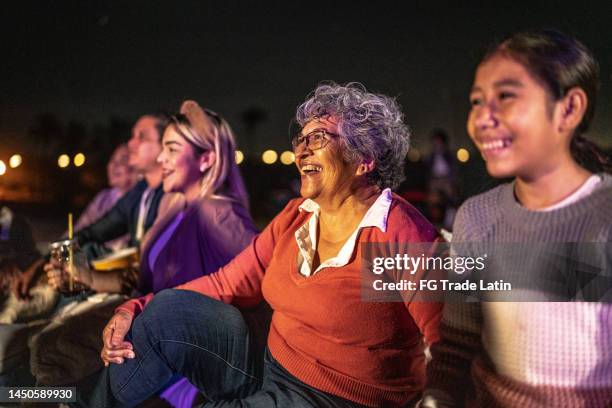 group of people enjoying a movie at the outdoors cinema - filmfestival stock pictures, royalty-free photos & images