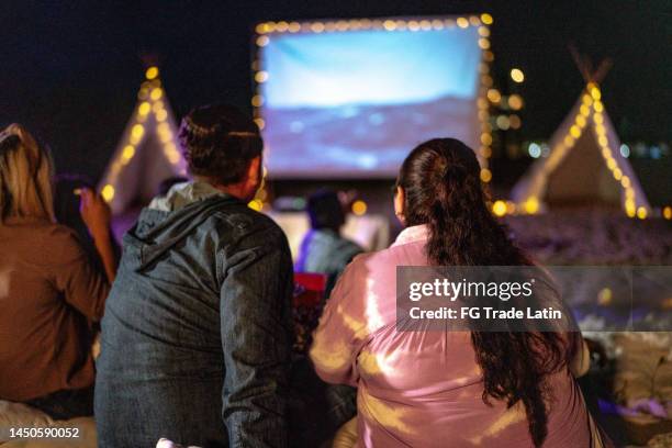 paar mit mittlerem erwachsenenalter, das sich einen film im kino im freien anschaut - open air kino stock-fotos und bilder