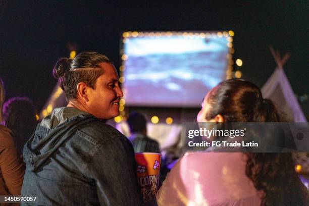 mid adult couple talking at the outdoors cinema - film festival stock pictures, royalty-free photos & images
