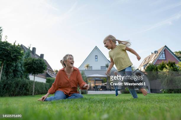 happy woman with daughter and son enjoying in back yard - eigenheim stock-fotos und bilder