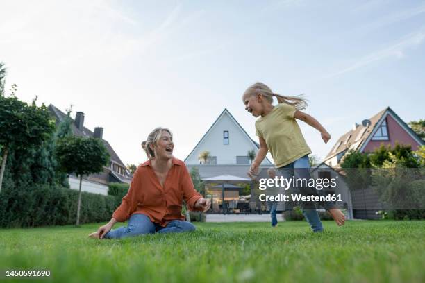 happy woman with daughter and son enjoying in back yard - baksida trädgård bildbanksfoton och bilder