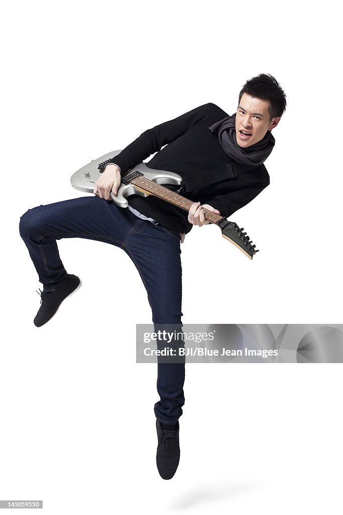 Stylish young man playing guitar