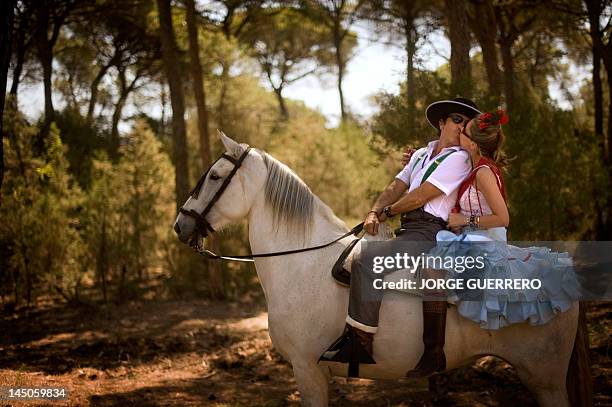 Couple of pilgrims kiss on a horse on the route to the shrine of El Rocio in Donana national park during the annual El Rocio pilgrimage, on May 23,...