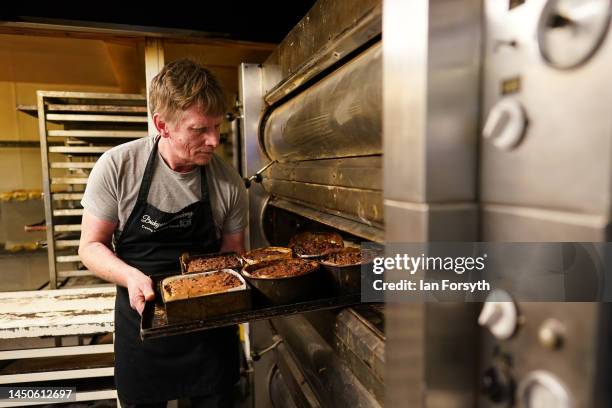 Baker Ed Trewhitt places a tray of Christmas cakes ordered by customers into the oven in his bakery on December 20, 2022 in Guisborough, England....