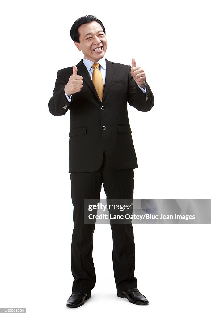 Senior businessman doing thumbs-up