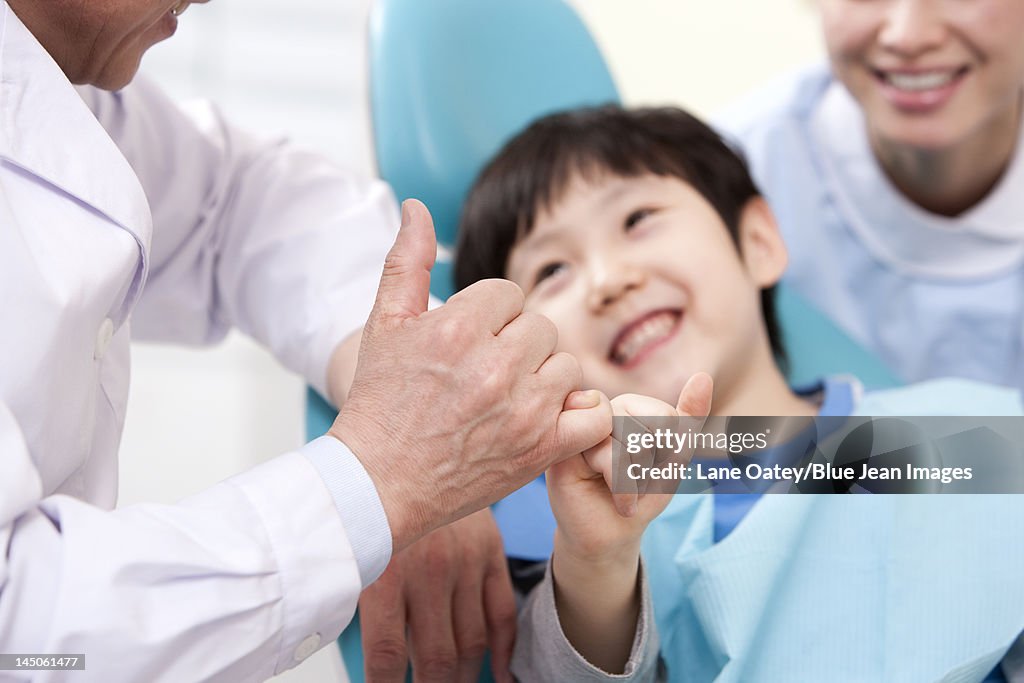 Dentist making promise with a little patient