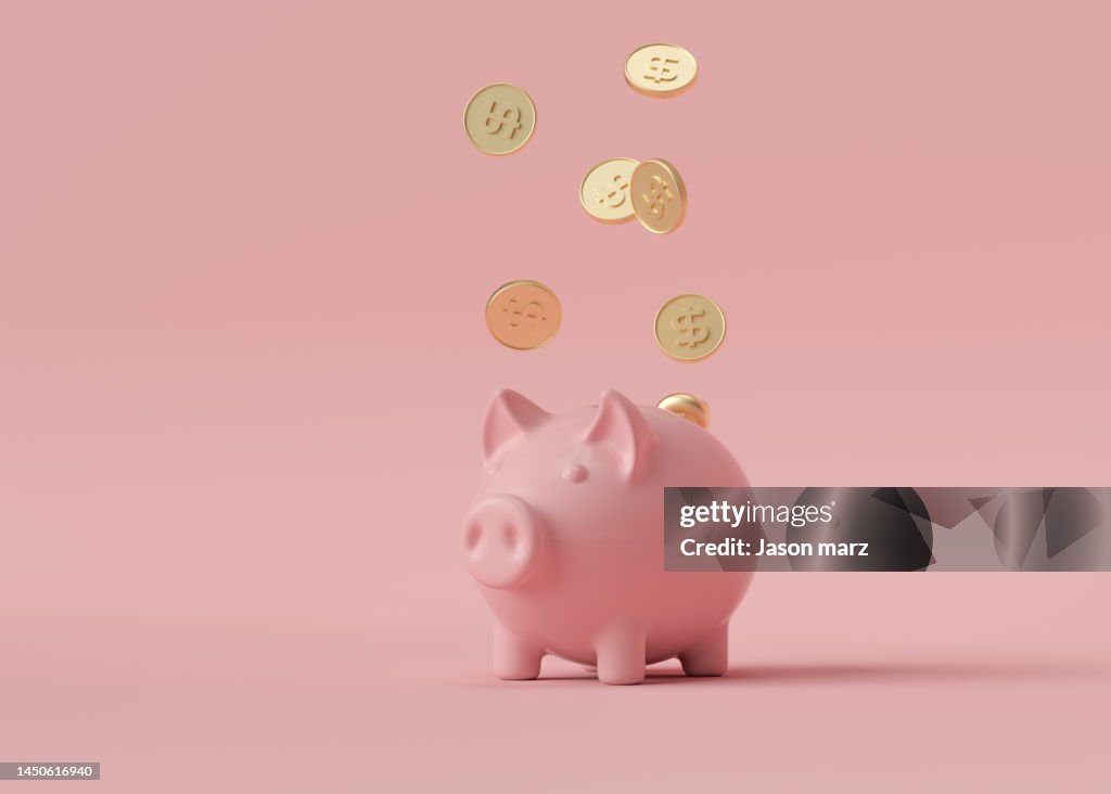 Gold coins falling into pink piggy bank