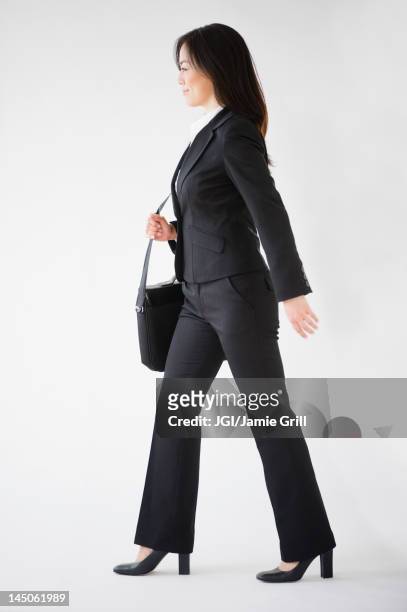 japanese businesswoman carrying briefcase - person walking side view stock pictures, royalty-free photos & images