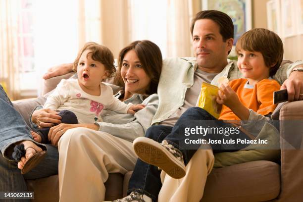 caucasian family watching television together - familia viendo la television fotografías e imágenes de stock