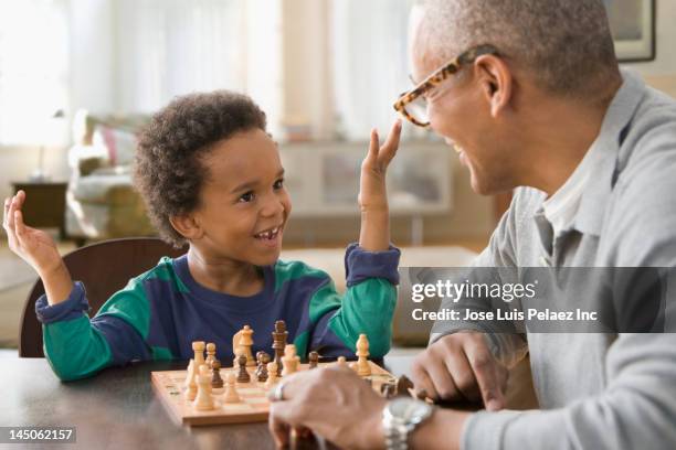 grandfather and grandson playing chess together - kids playing chess stock pictures, royalty-free photos & images