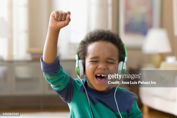 black boy listening to music on headphones - boy headphones imagens e fotografias de stock