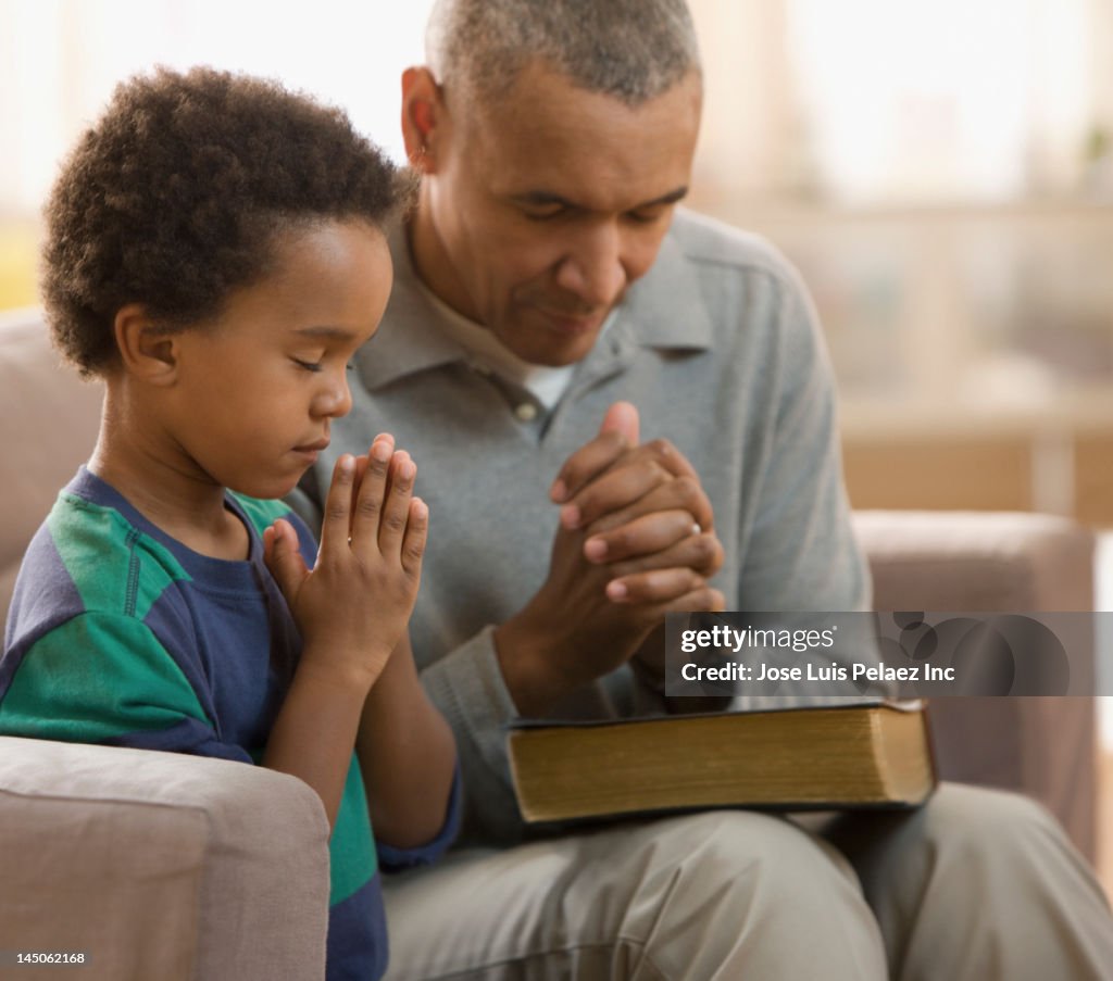 Grandfather and grandson praying together