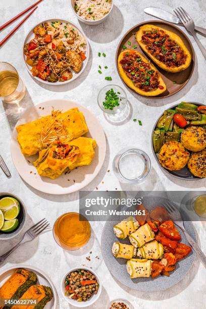table filled with various dishes including chop suey, stuffed potatoes, fajitas, rice muffins, ricotta rolls and various salads - mexican food on table stock pictures, royalty-free photos & images