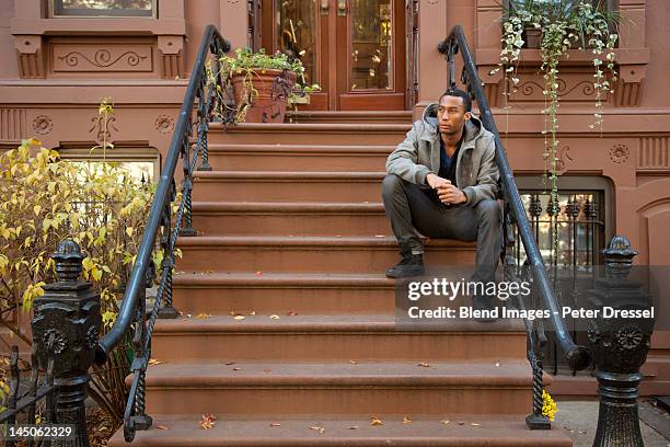 black man sitting on front stoop - perron photos et images de collection