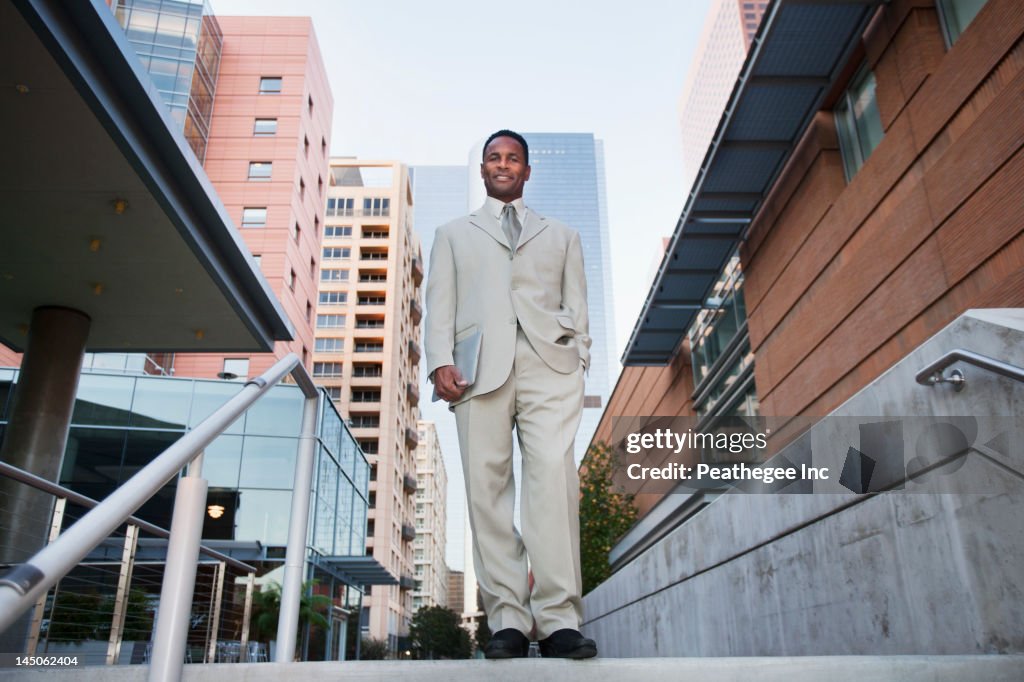 African American businessman standing at top of stairs