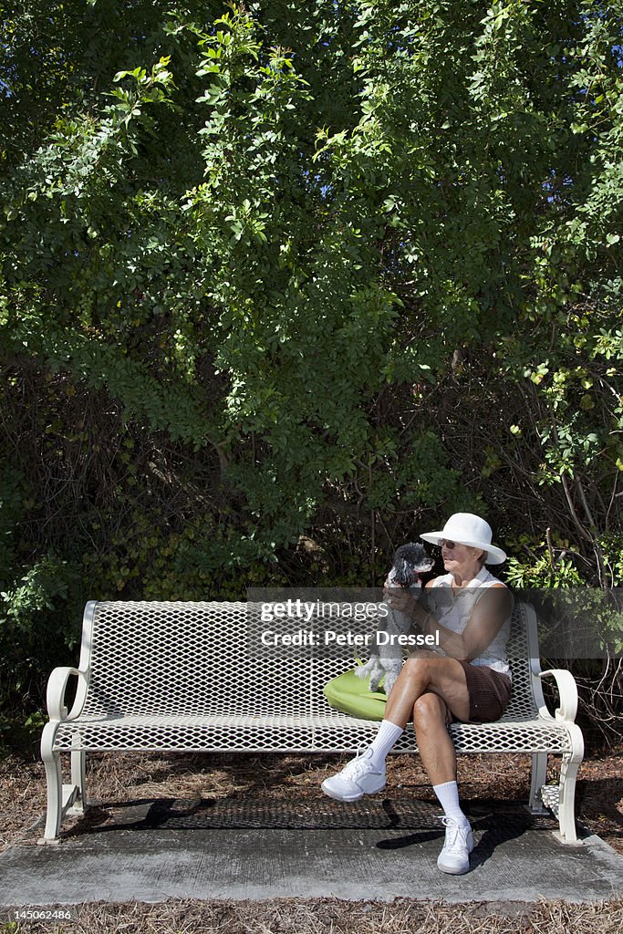 Caucasian woman sitting on park bench with dog