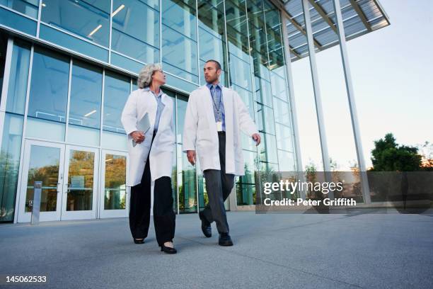 doctors walking together outdoors - entrance building people stock pictures, royalty-free photos & images