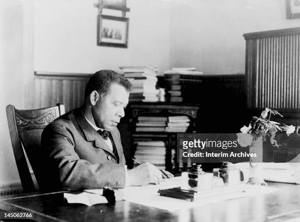 Seated portrait of American educator, economist, and industrialist Booker T Washington , founder of the Tuskegee Institute in Alabama, at his desk,...