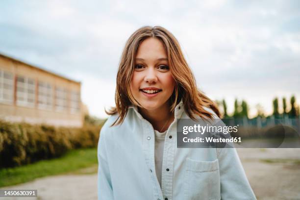 happy girl with blond hair wearing denim shirt - alleen tieners stockfoto's en -beelden