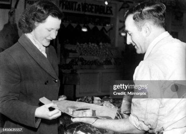 Woman collects her meat ration from a butcher. 12th January, 1951.