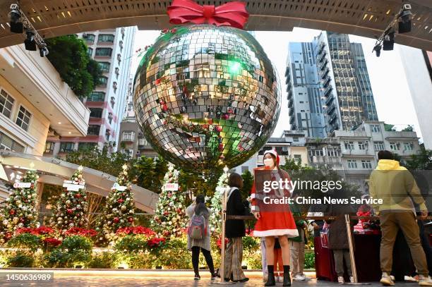 Visitor takes photos of a Christmas decoration hanging over Christmas trees at Lee Tung Avenue on December 20, 2022 in Hong Kong, China.