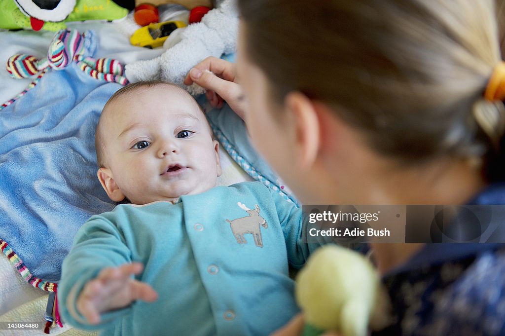 Girl playing with baby brother on bed