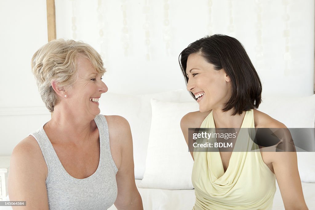 Women laughing together on sofa