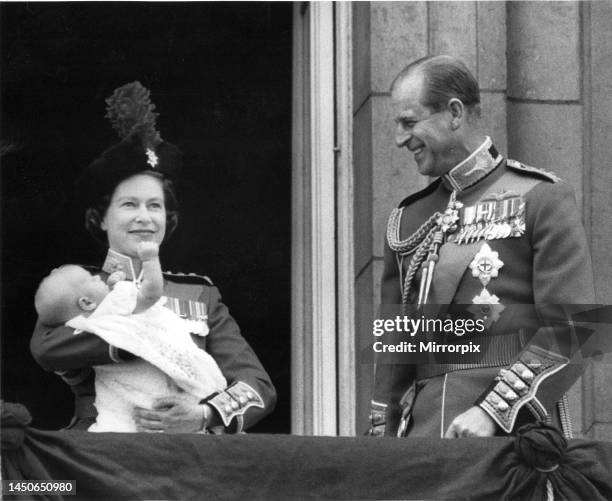 Queen Elizabeth II holds her youngest son Prince Edward in her arms as she stands with her husband Prince Philip, the Duke of Edinburgh, on the...