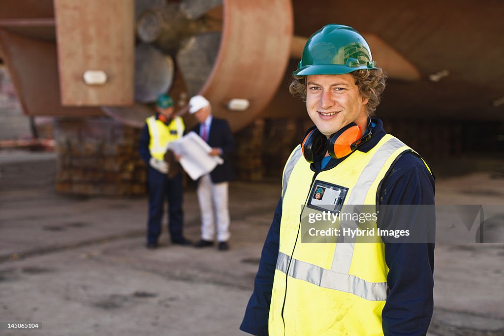 Smiling worker standing on dry dock