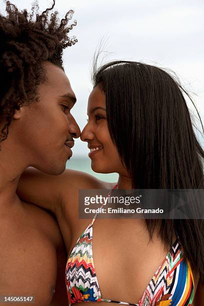 a young couple with arms around each other - hot puerto rican women stock-fotos und bilder
