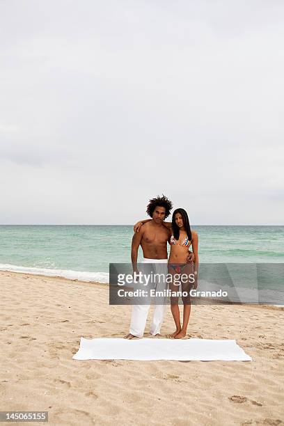 an attractive young couple standing on a beach - hot puerto rican women stock-fotos und bilder