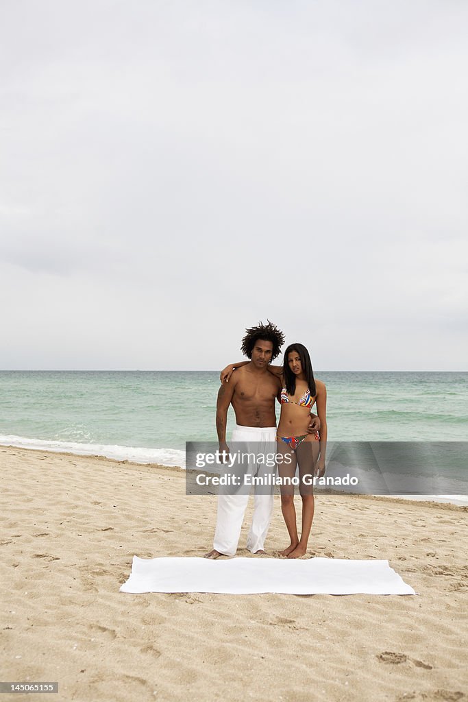 An attractive young couple standing on a beach