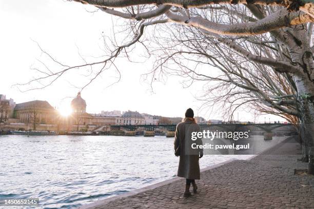woman walks along  seine river in paris, winter season december - walking around the french capital stockfoto's en -beelden