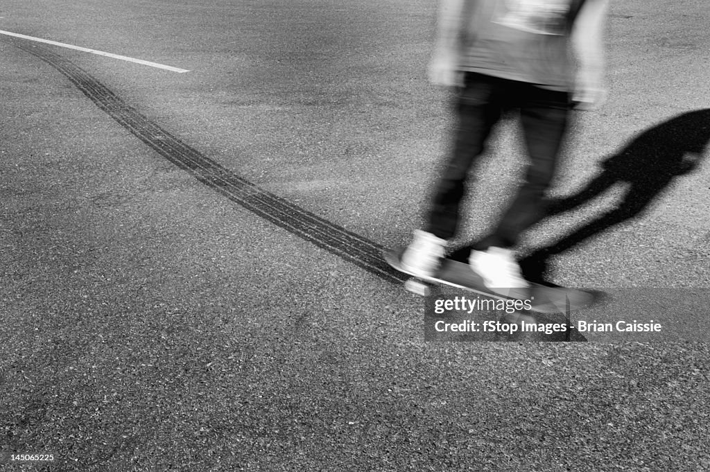 A skateboarder leaving tire tracks