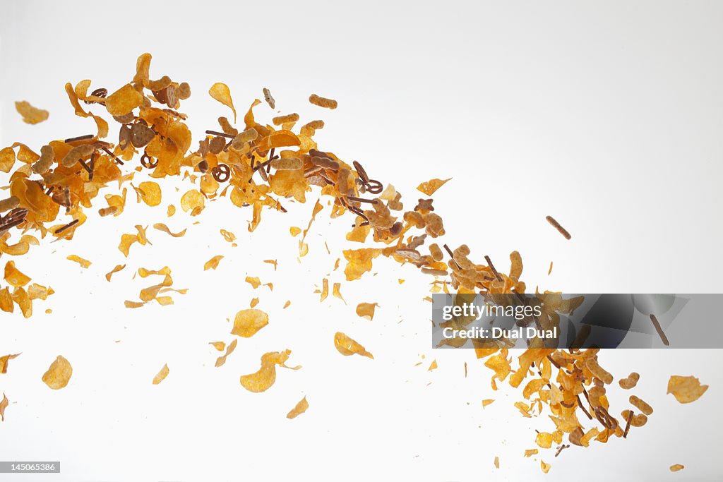 Chips, pretzels and savory snacks against a white background