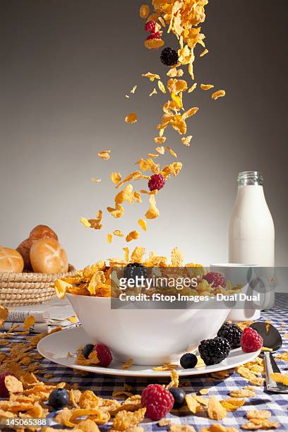 cereal and fruit being poured into a bowl - bowl of cornflakes stock-fotos und bilder