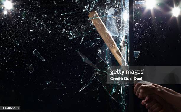 detail of a man smashing glass with a baseball bat - baseballschläger stock-fotos und bilder