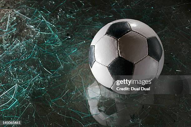a soccer ball on broken glass - fragilidad fotografías e imágenes de stock